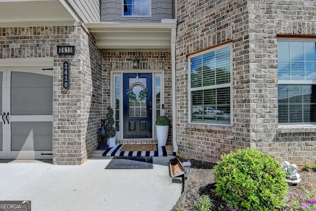 2410 Melton Common Dr, Dacula, GA 30019 - view of exterior entry with a garage, brick siding, and stone siding