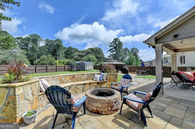 2410 Melton Common Dr, Dacula, GA 30019 - fenced backyard featuring an outdoor fire pit, a storage shed, a patio area, outdoor dining space, and a gazebo