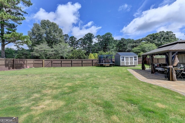 2410 Melton Common Dr, Dacula, GA 30019 - fenced backyard with a gazebo, a storage unit, a patio area, and a trampoline
