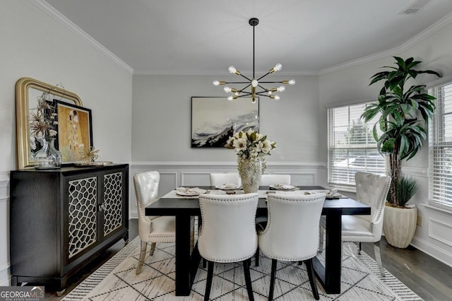 2410 Melton Common Dr, Dacula, GA 30019 - dining room with a chandelier, crown molding, a wainscoted wall, wood finished floors, and a decorative wall