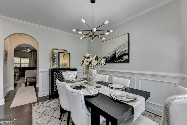 2410 Melton Common Dr, Dacula, GA 30019 - dining area with crown molding, arched walkways, wood finished floors, a chandelier, and a wainscoted wall