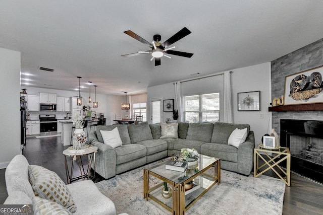 2410 Melton Common Dr, Dacula, GA 30019 - living area with dark wood-type flooring, a fireplace, and ceiling fan