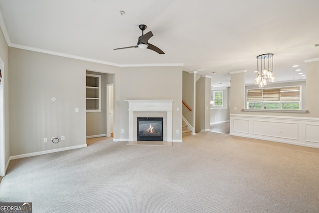 11302 Musette Cir, Alpharetta, GA 30009 - unfurnished living room with ornamental molding, a ceiling fan, a fireplace with flush hearth, light carpet, and a chandelier