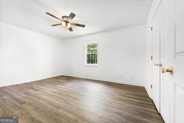 665 Center Of The World Rd, Canon, GA 30520 - empty room with a ceiling fan, dark wood-type flooring, and a textured ceiling