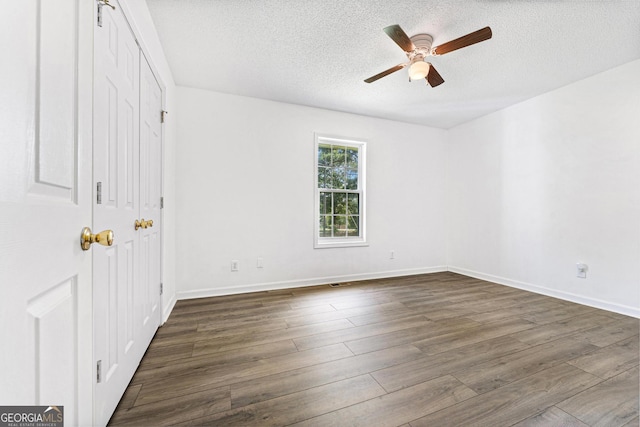 665 Center Of The World Rd, Canon, GA 30520 - unfurnished bedroom featuring dark wood-style flooring, a textured ceiling, a ceiling fan, and a closet