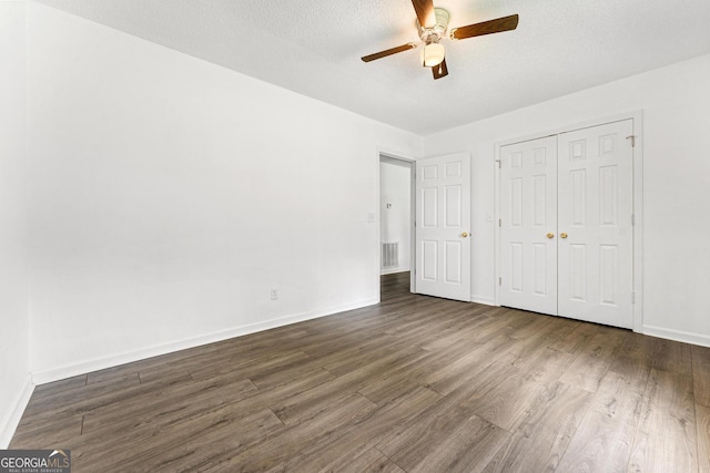 665 Center Of The World Rd, Canon, GA 30520 - unfurnished bedroom with dark wood-style flooring, a closet, ceiling fan, and a textured ceiling