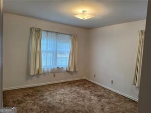 1046 Sans Souci Way, Clarkston, GA 30021 - empty room with baseboards and carpet
