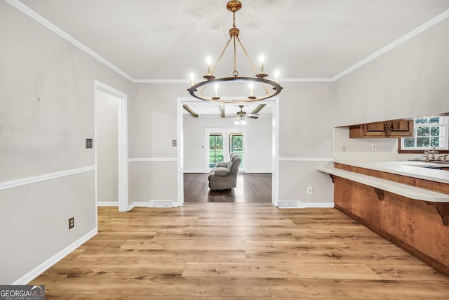 105 Skyline Dr, Barnesville, GA 30204 - kitchen featuring plenty of natural light, light countertops, a chandelier, light wood-style flooring, and crown molding
