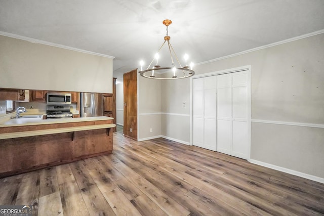 105 Skyline Dr, Barnesville, GA 30204 - kitchen with appliances with stainless steel finishes, a chandelier, wood finished floors, light countertops, and a peninsula