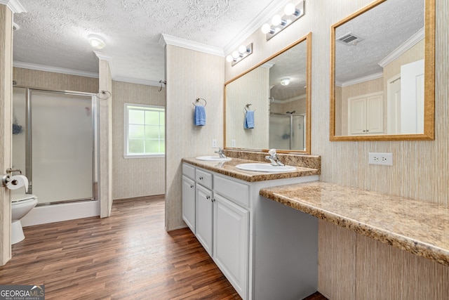 319 Aderhold Rd, Carnesville, GA 30521 - full bathroom with a textured ceiling, wood finished floors, ornamental molding, a shower stall, and double vanity