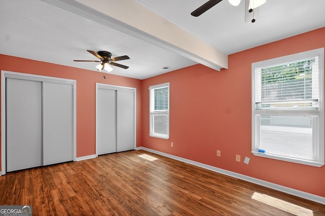352 Grayson Trl, Hogansville, GA 30230 - unfurnished bedroom with multiple closets, wood finished floors, beamed ceiling, and ceiling fan