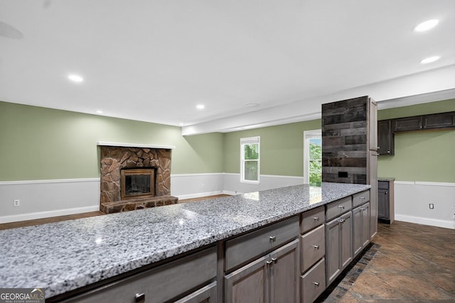 352 Grayson Trl, Hogansville, GA 30230 - kitchen with light stone counters, recessed lighting, a stone fireplace, open floor plan, and gray cabinets
