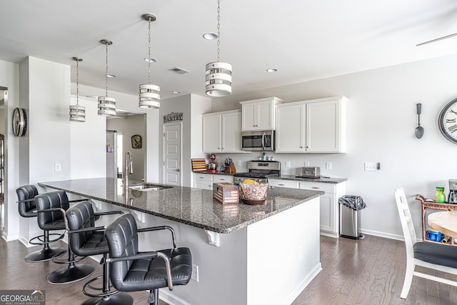 107 Topaz St, Calhoun, GA 30701 - kitchen with appliances with stainless steel finishes, a breakfast bar area, dark stone counters, and recessed lighting