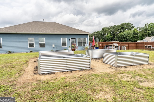 107 Topaz St, Calhoun, GA 30701 - rear view of property featuring a garden, a fenced backyard, and roof with shingles