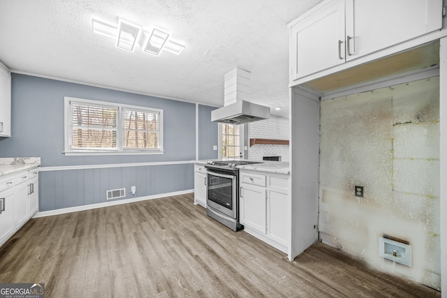 2511 Due W Cir NW, Kennesaw, GA 30152 - kitchen featuring stainless steel gas range oven, light wood-style floors, a textured ceiling, white cabinetry, and a wainscoted wall