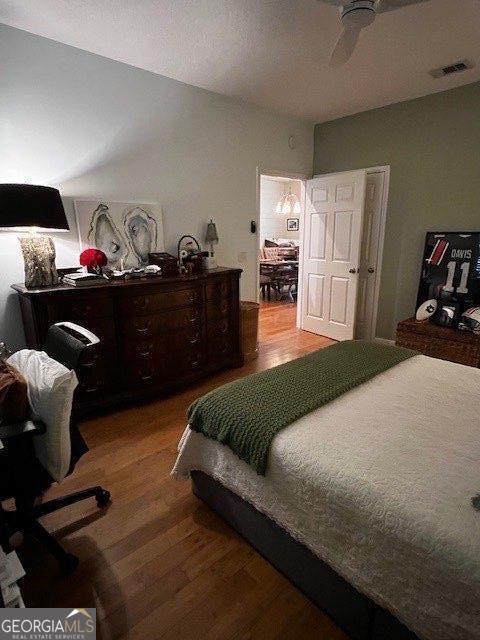 324 Moss Creek Ln, Brunswick, GA 31520 - bedroom with wood finished floors, an office area, and a ceiling fan