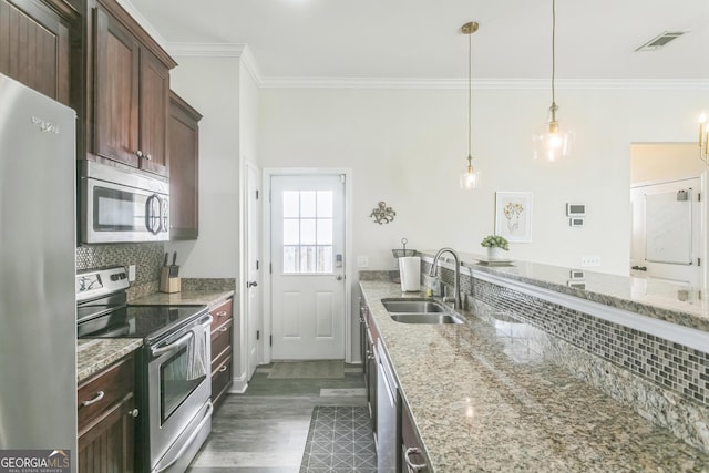 309 E 41st St, Savannah, GA 31401 - kitchen with appliances with stainless steel finishes, ornamental molding, decorative backsplash, light stone counters, and pendant lighting