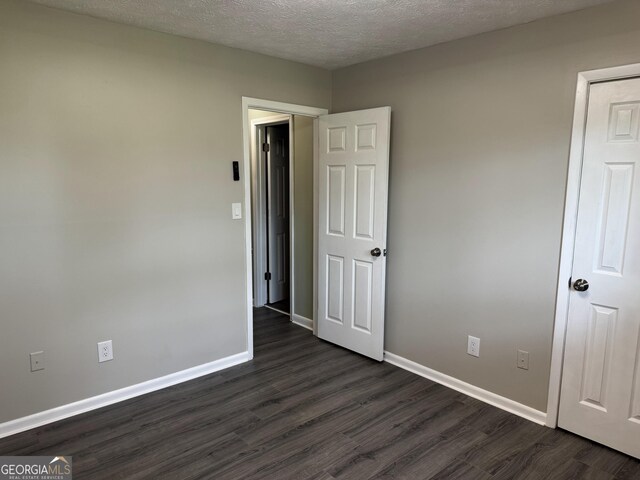 501 Carlton Rd Unit 3-D, Palmetto, GA 30268 - unfurnished bedroom featuring dark wood finished floors and a textured ceiling