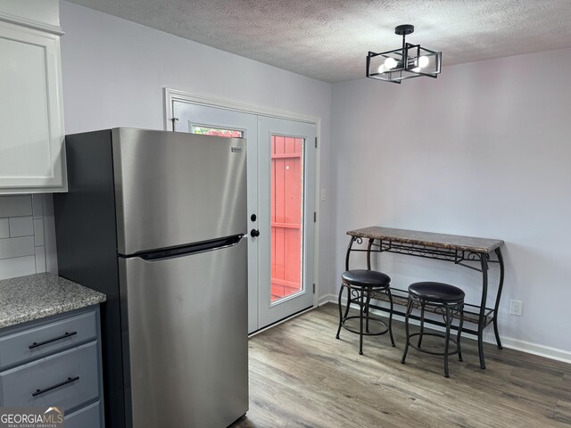 501 Carlton Rd Unit 3-D, Palmetto, GA 30268 - kitchen with freestanding refrigerator, wood finished floors, a textured ceiling, backsplash, and light countertops