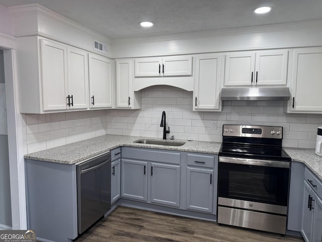501 Carlton Rd Unit 3-D, Palmetto, GA 30268 - kitchen with stainless steel appliances, under cabinet range hood, decorative backsplash, white cabinets, and crown molding
