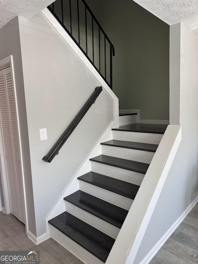 501 Carlton Rd Unit 3-D, Palmetto, GA 30268 - staircase featuring wood finished floors and a textured ceiling