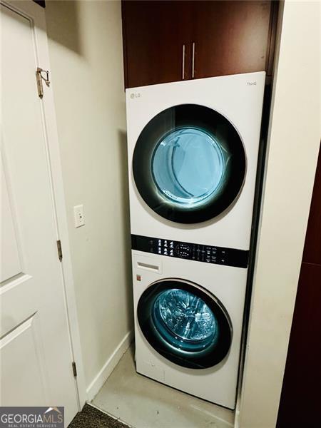 400 Peachtree St Unit 3412, Atlanta, GA 30308 - laundry room featuring estacked washer and dryer and baseboards