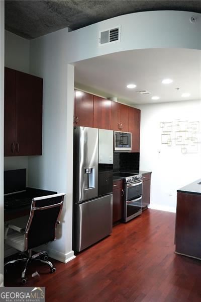 400 Peachtree St Unit 3412, Atlanta, GA 30308 - kitchen featuring stainless steel appliances, dark wood-style flooring, a desk, decorative backsplash, and recessed lighting
