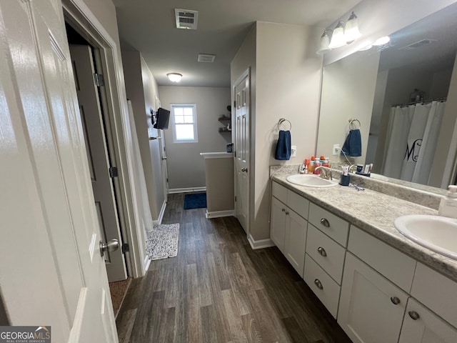 307 Pardue Dr, Thomaston, GA 30286 - bathroom with wood finished floors, double vanity, and a shower with shower curtain