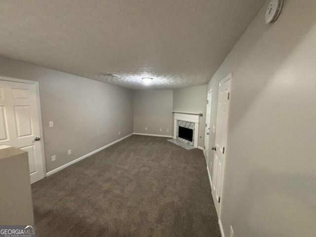 2183 Ramblewood Cir, Decatur, GA 30035 - unfurnished living room with a fireplace, a textured ceiling, and dark colored carpet