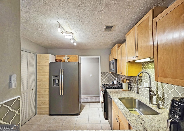 1202 Countryside Pl SE, Smyrna, GA 30080 - kitchen featuring appliances with stainless steel finishes, light tile patterned floors, light stone countertops, and decorative backsplash