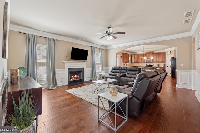 2629 Muskeg Ct SW, Atlanta, GA 30331 - living room featuring ceiling fan, arched walkways, a wainscoted wall, ornamental molding, and a fireplace with flush hearth