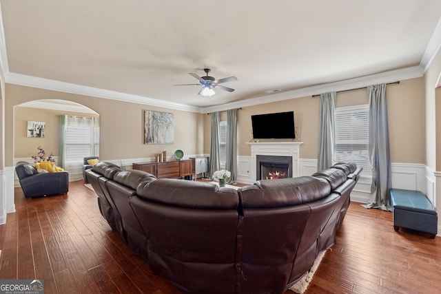 2629 Muskeg Ct SW, Atlanta, GA 30331 - living area featuring arched walkways, a ceiling fan, a wainscoted wall, a warm lit fireplace, and dark wood-type flooring