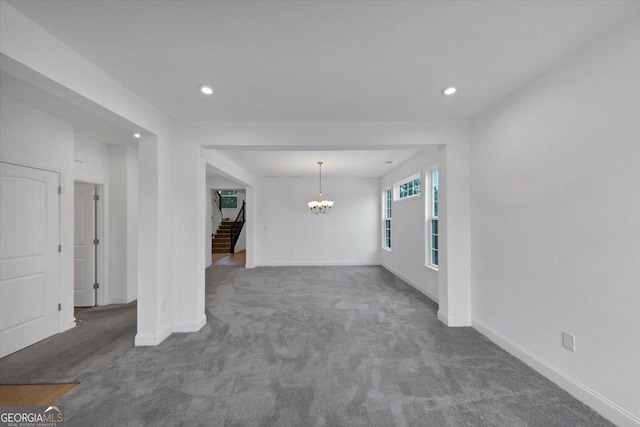 612 Michigan Cir, Hoschton, GA 30548 - unfurnished living room with a chandelier, carpet flooring, stairway, and recessed lighting