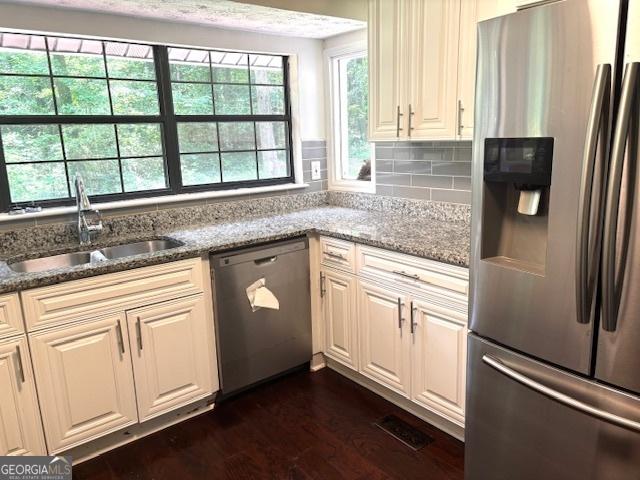 7813 Sugarland Dr, Jonesboro, GA 30236 - kitchen with stainless steel appliances, dark wood-style floors, light stone counters, and decorative backsplash