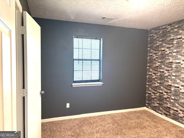 7813 Sugarland Dr, Jonesboro, GA 30236 - empty room featuring a textured ceiling and carpet flooring
