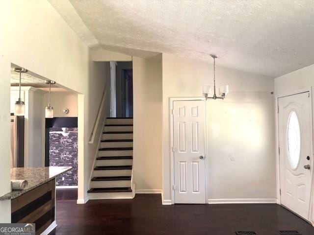 7813 Sugarland Dr, Jonesboro, GA 30236 - entryway with vaulted ceiling, a textured ceiling, stairs, dark wood-style floors, and a chandelier