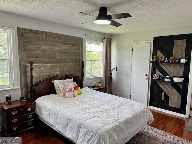 912 Pineland Ave Apt 50, Hinesville, GA 31313 - bedroom featuring dark wood-type flooring, a textured ceiling, and a ceiling fan