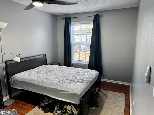 912 Pineland Ave Apt 50, Hinesville, GA 31313 - bedroom with dark wood-type flooring, a textured ceiling, and ceiling fan