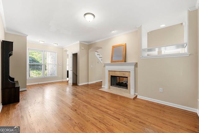733 Miller Run, Atlanta, GA 30349 - unfurnished living room featuring arched walkways, a fireplace, ornamental molding, and light wood-type flooring