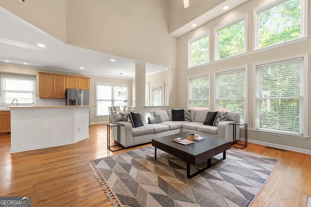 733 Miller Run, Atlanta, GA 30349 - living room featuring a towering ceiling, light wood-type flooring, ornate columns, and recessed lighting