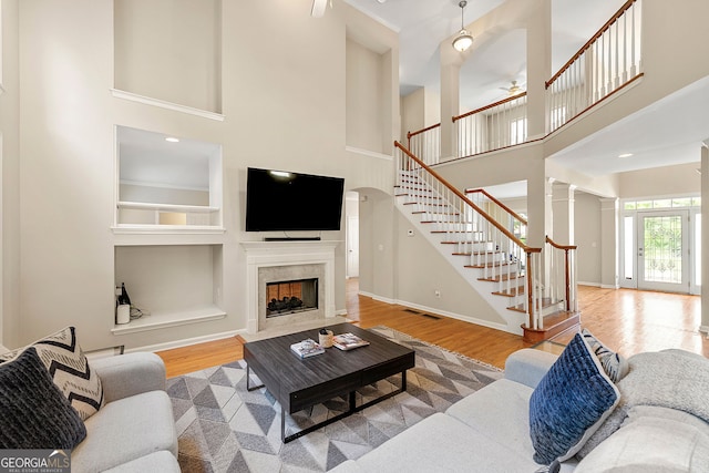 733 Miller Run, Atlanta, GA 30349 - living area with a towering ceiling, stairs, wood finished floors, a ceiling fan, and a high end fireplace