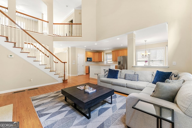 733 Miller Run, Atlanta, GA 30349 - living area with stairway, a chandelier, light wood-style flooring, crown molding, and recessed lighting