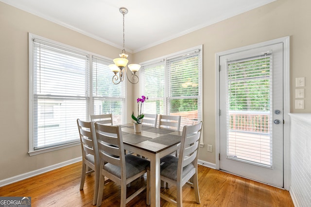 733 Miller Run, Atlanta, GA 30349 - dining area with a chandelier, light wood finished floors, healthy amount of natural light, and crown molding