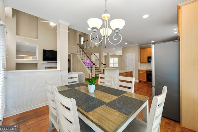 733 Miller Run, Atlanta, GA 30349 - dining room with stairway, wood finished floors, ornate columns, recessed lighting, and a chandelier
