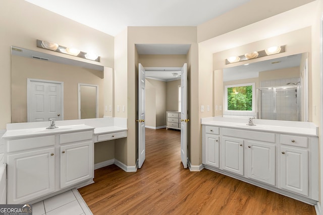 733 Miller Run, Atlanta, GA 30349 - bathroom with a shower stall, two vanities, and wood finished floors