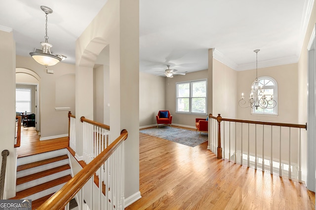 733 Miller Run, Atlanta, GA 30349 - hall featuring light wood-style flooring, an upstairs landing, arched walkways, a chandelier, and crown molding