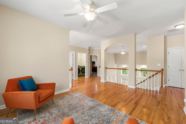733 Miller Run, Atlanta, GA 30349 - sitting room with washer / dryer, an upstairs landing, wood finished floors, ceiling fan, and arched walkways