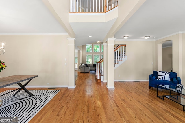 733 Miller Run, Atlanta, GA 30349 - entrance foyer featuring ornate columns, light wood-style flooring, stairway, arched walkways, and ornamental molding