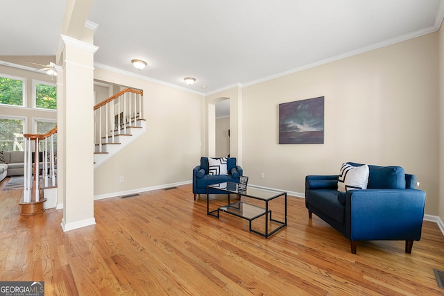 733 Miller Run, Atlanta, GA 30349 - living area with stairs, a ceiling fan, light wood finished floors, ornamental molding, and arched walkways