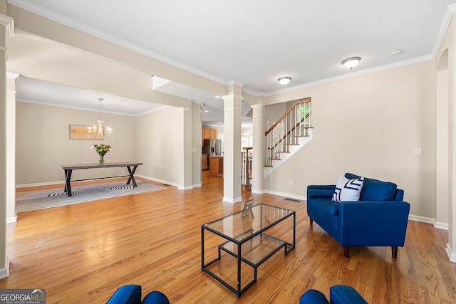733 Miller Run, Atlanta, GA 30349 - living room featuring decorative columns, crown molding, light wood-style floors, a chandelier, and stairs